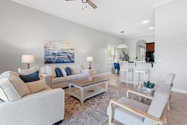 living room featuring ceiling fan, light tile patterned floors, and ornamental molding