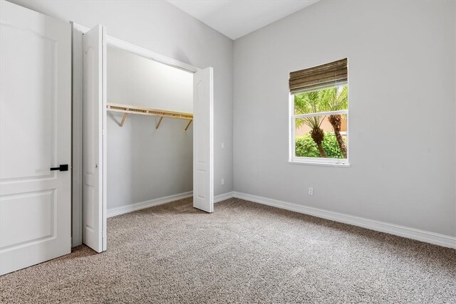 unfurnished bedroom featuring carpet and a closet