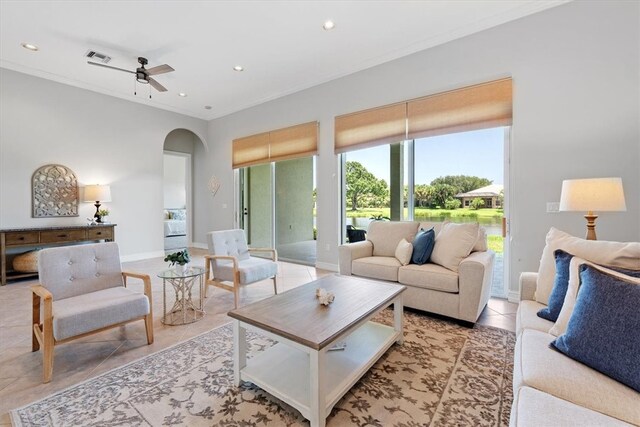 tiled living room with ceiling fan and crown molding