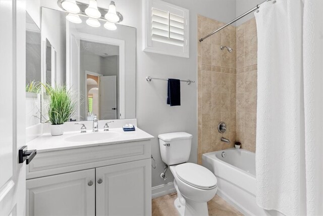 full bathroom featuring tile patterned floors, vanity, shower / bath combination with curtain, and toilet