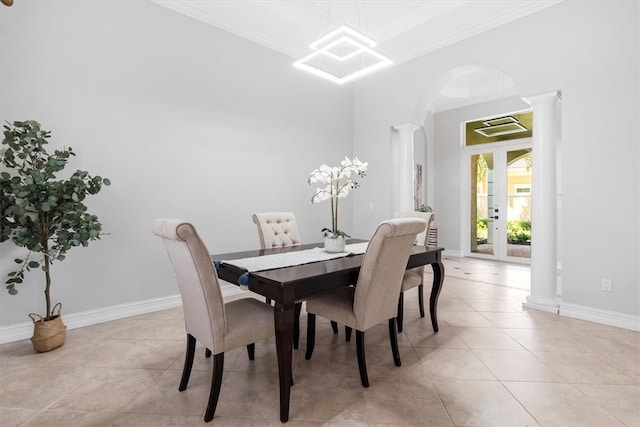 tiled dining room with ornate columns, ornamental molding, and a notable chandelier