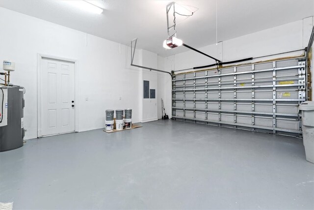 garage featuring electric panel, electric water heater, and a garage door opener