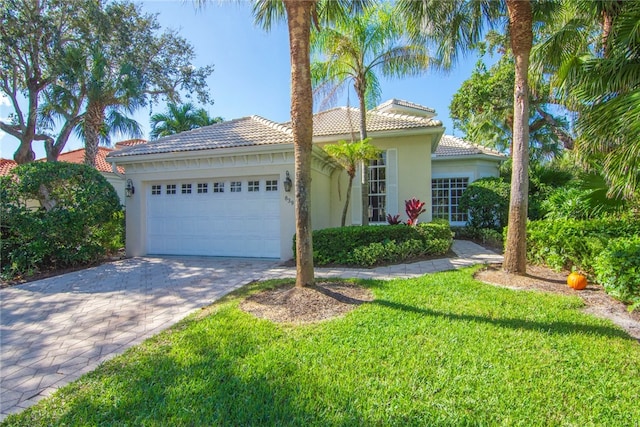 839 Island Club Sq, Vero Beach, FL 32963 - mediterranean / spanish-style house featuring stucco siding, an attached garage, a tile roof, decorative driveway, and a front yard