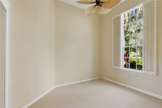 carpeted spare room with baseboards and a ceiling fan