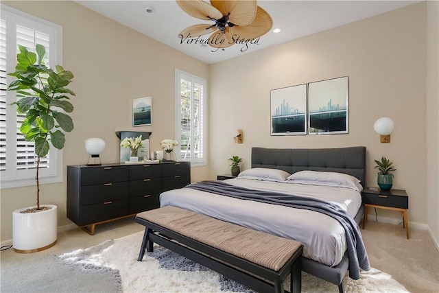 bedroom with light carpet, ceiling fan, and baseboards