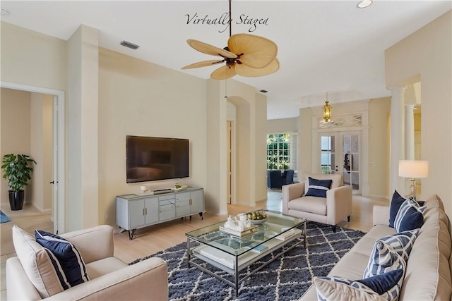 living room featuring wood finished floors, decorative columns, visible vents, and a ceiling fan