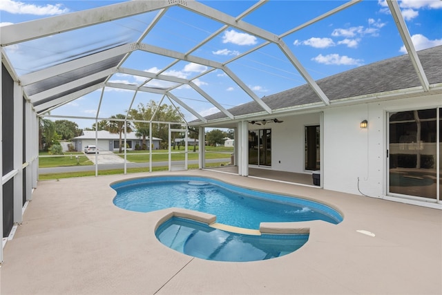 view of pool featuring glass enclosure, a patio area, and ceiling fan