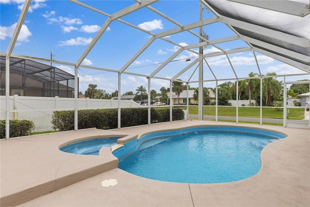 view of swimming pool with a lawn, glass enclosure, an in ground hot tub, and a patio