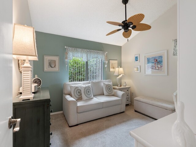 living room featuring a textured ceiling, light colored carpet, ceiling fan, and vaulted ceiling