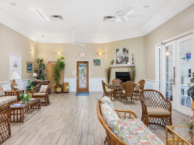 living room with a wealth of natural light, light hardwood / wood-style floors, and ceiling fan