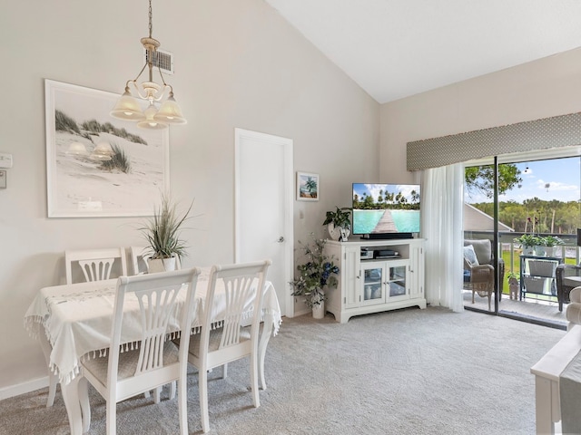 dining room with high vaulted ceiling, a chandelier, and light colored carpet