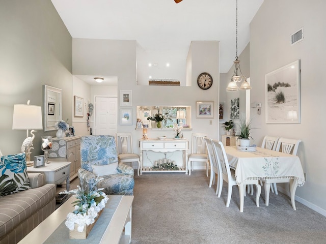 carpeted living room with high vaulted ceiling