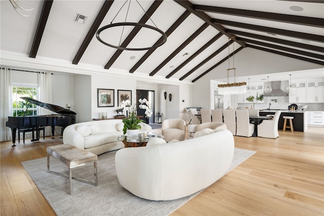 living room with beamed ceiling, high vaulted ceiling, and light wood finished floors