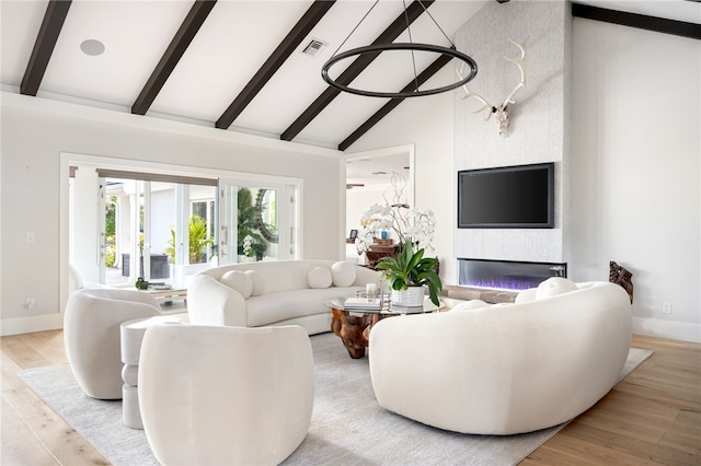 living room featuring beamed ceiling, baseboards, high vaulted ceiling, light wood-style floors, and a fireplace