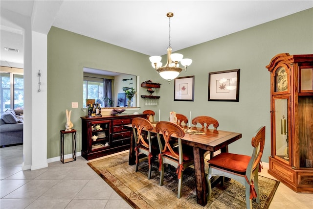 dining area with a chandelier and light tile patterned floors