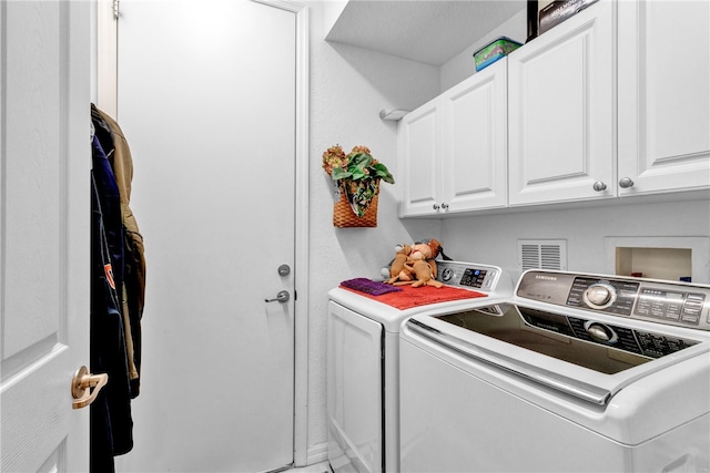 washroom with cabinets and washer and clothes dryer