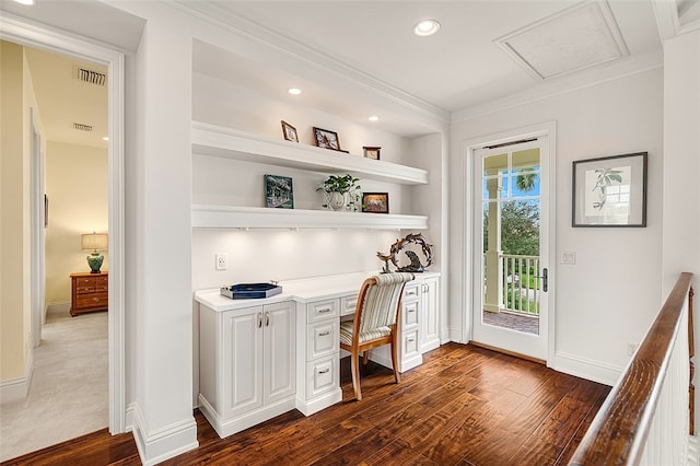 office area with built in desk, dark hardwood / wood-style floors, and ornamental molding