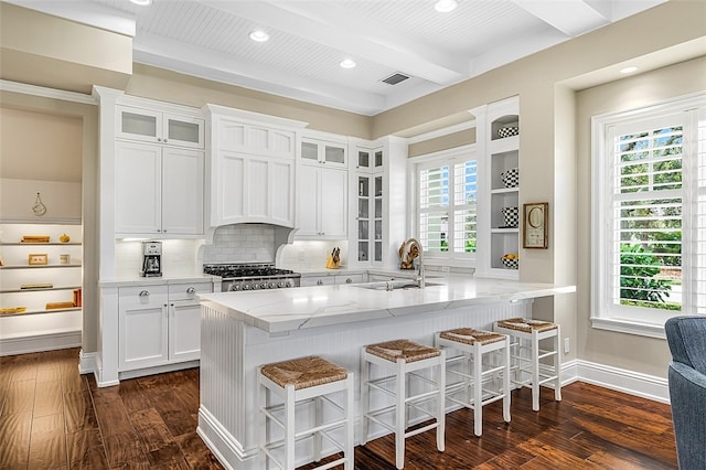 kitchen featuring white cabinets, beam ceiling, dark wood-type flooring, and sink