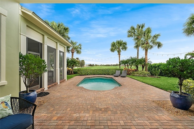 view of swimming pool featuring a lawn and a patio