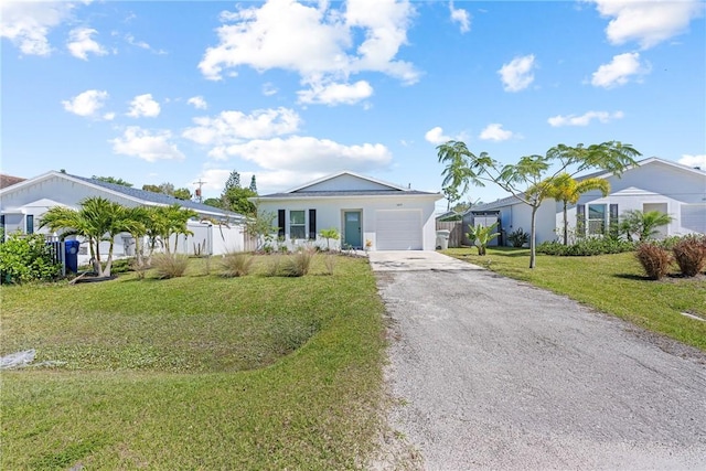 view of front facade with driveway, an attached garage, fence, and a front yard