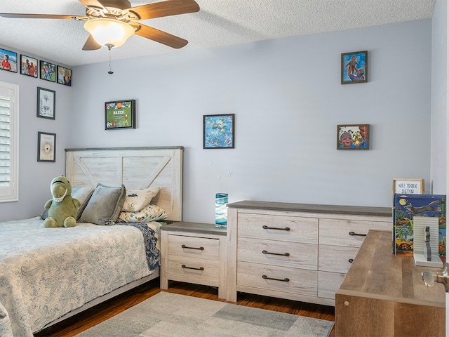 bedroom with ceiling fan, dark hardwood / wood-style floors, and a textured ceiling