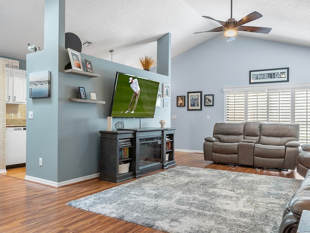 living room with hardwood / wood-style floors, a textured ceiling, high vaulted ceiling, and ceiling fan