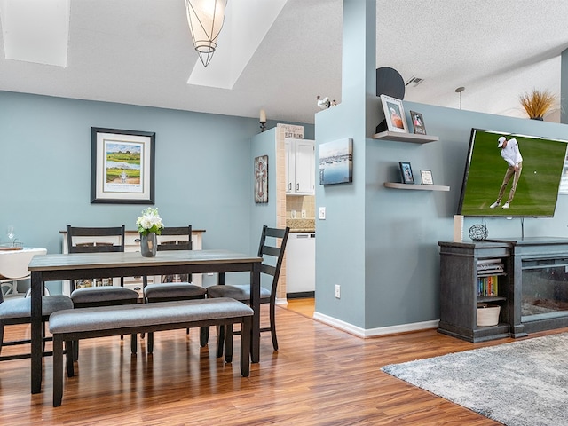 dining room featuring a textured ceiling and light wood-type flooring