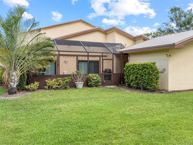 back of property with a yard and a lanai