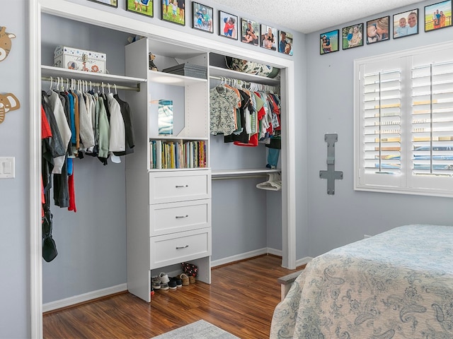 bedroom featuring dark hardwood / wood-style floors, a textured ceiling, and a closet