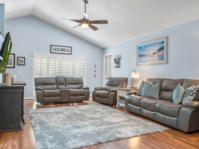 living room featuring a textured ceiling, hardwood / wood-style flooring, ceiling fan, and lofted ceiling