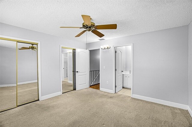 1901 Indian River Blvd Unit 202D, Vero Beach, FL 32960 - unfurnished bedroom featuring two closets, carpet flooring, a textured ceiling, connected bathroom, and ceiling fan