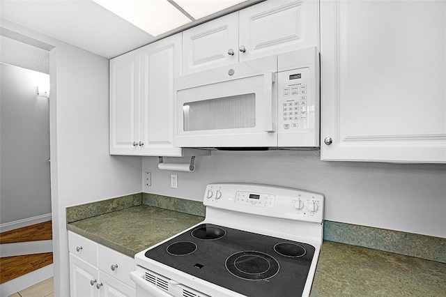 1901 Indian River Blvd Unit 202D, Vero Beach, FL 32960 - kitchen featuring white appliances, dark countertops, and white cabinets