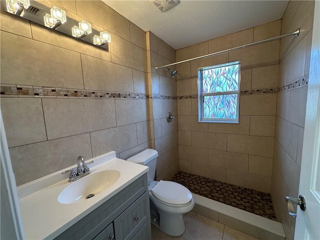 full bath with visible vents, tiled shower, toilet, and vanity