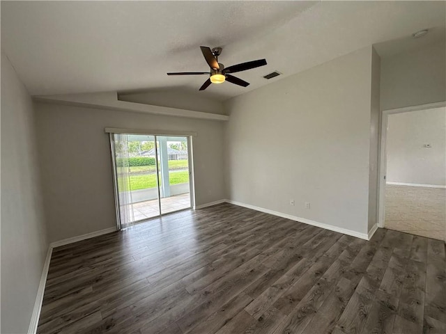 unfurnished room featuring visible vents, lofted ceiling, dark wood-type flooring, and baseboards