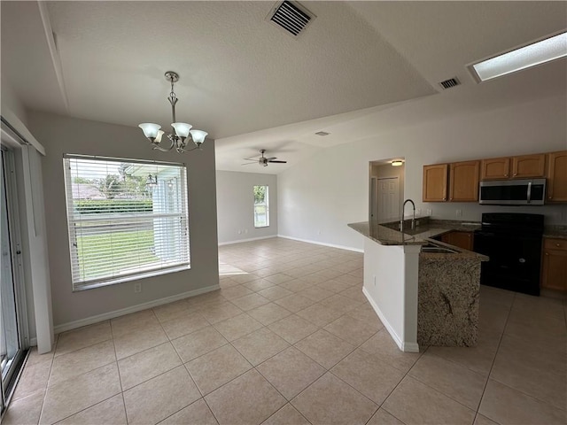 kitchen featuring stainless steel microwave, visible vents, black range with electric cooktop, a peninsula, and light tile patterned flooring