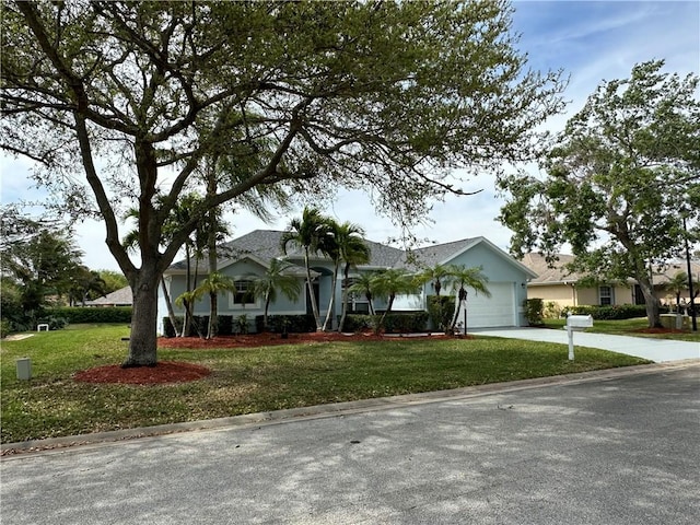 single story home with concrete driveway, an attached garage, and a front yard