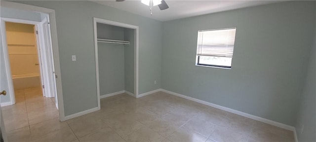 unfurnished bedroom with light tile patterned floors, a closet, and ceiling fan