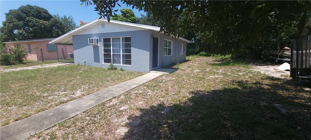 view of home's exterior featuring a lawn and an AC wall unit