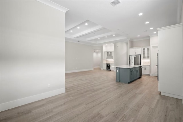1820 Arawak St, Vero Beach, FL 32967 - kitchen featuring wine cooler, an island with sink, light countertops, white cabinets, and stainless steel appliances