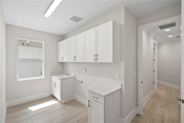 1820 Arawak St, Vero Beach, FL 32967 - washroom with washer hookup, light wood-type flooring, cabinet space, and visible vents