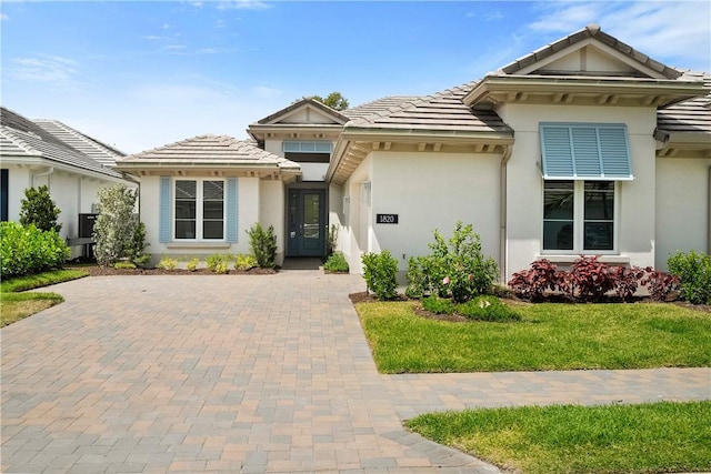 1820 Arawak St, Vero Beach, FL 32967 - view of front facade with a garage, stucco siding, decorative driveway, and a tile roof