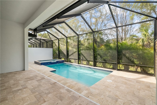 view of pool with a lanai, a patio, and an in ground hot tub