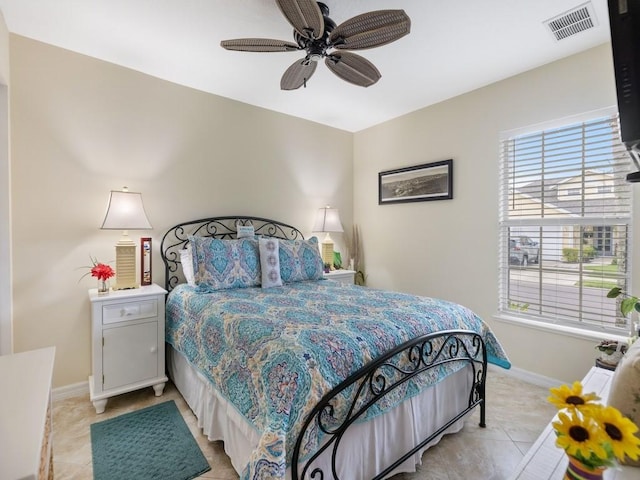 bedroom featuring baseboards, light tile patterned floors, and a ceiling fan