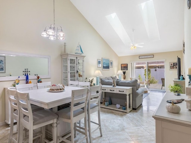 dining room with high vaulted ceiling, a chandelier, and a skylight