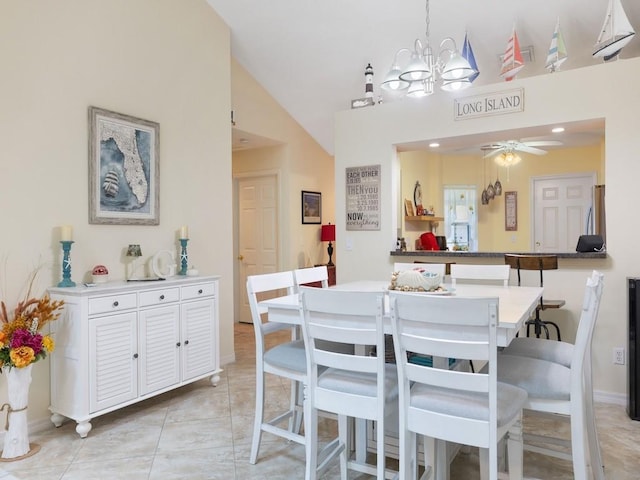 dining room featuring a ceiling fan, lofted ceiling, a chandelier, and baseboards