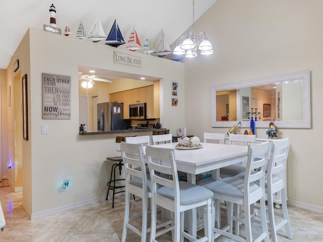dining room with a high ceiling, ceiling fan, baseboards, and a chandelier