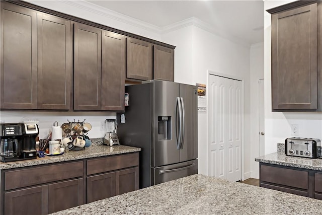 4308 Lago Vista Dr, Sebastian, FL 32976 - kitchen with stainless steel fridge, dark brown cabinetry, light stone counters, crown molding, and wood finished floors