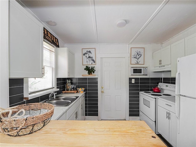 2047 38th Ave, Vero Beach, FL 32960 - kitchen with white appliances, under cabinet range hood, white cabinetry, light countertops, and decorative backsplash