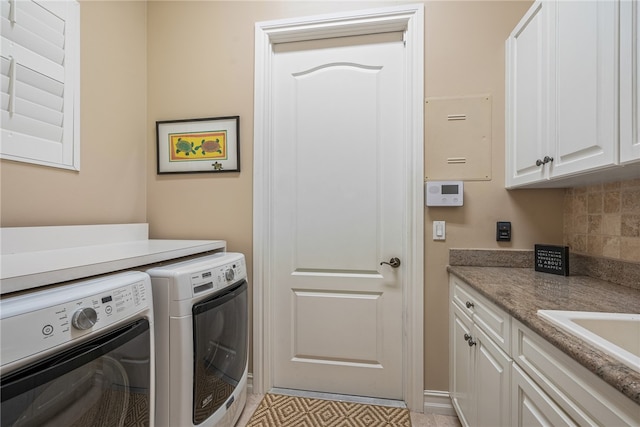 washroom with cabinets and washing machine and clothes dryer