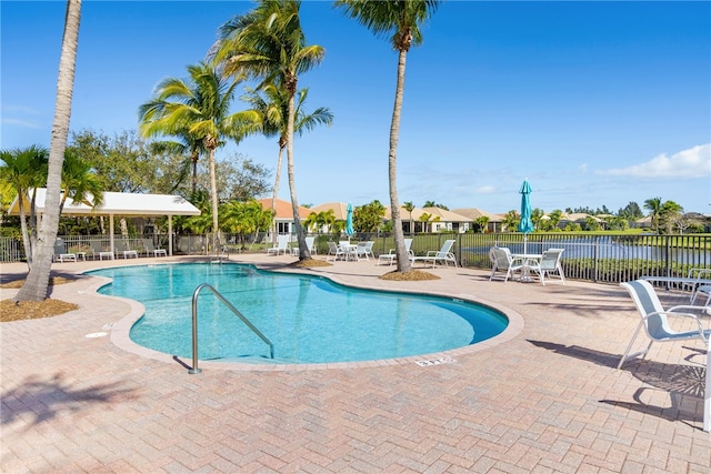 view of pool with a patio area and a water view